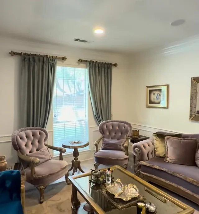 Gray curtains tied back beside white horizontal blinds in a formal sitting room.